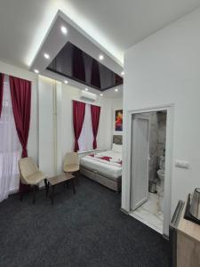 a hotel room with a bed and two chairs at 15 PERCENT OFF UNTIL 31st OF AUGUST ABC Luxury Space with 7 suites for 15 Guests - One Suite with Hot Tub and Sauna, Paid Parking on-site, Mandatory Reservation in Belgrade