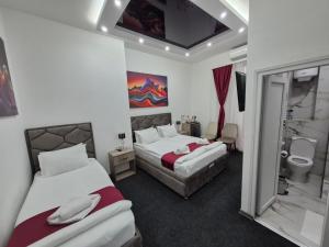 a hotel room with two beds and a bathroom at 15 PERCENT OFF UNTIL 31st OF AUGUST ABC Luxury Space with 7 suites for 15 Guests - One Suite with Hot Tub and Sauna, Paid Parking on-site, Mandatory Reservation in Belgrade