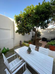 a picnic table with chairs and an orange tree at 21 L'Agrumeto in Marittima
