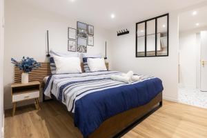 a bedroom with a large bed with blue and white sheets at Chic & beau au centre Millau in Millau