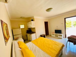 a living room with a yellow bed and a kitchen at Hurghada-Magawish Studio 2 in Hurghada