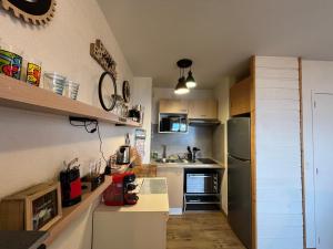 a small kitchen with white cabinets and a refrigerator at Appartement lumineux avec piscine et parking à Évian - FR-1-498-109 in Évian-les-Bains
