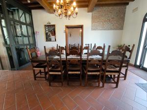 una sala da pranzo con tavolo, sedie e lampadario pendente di Volivia Relais a Pegognaga Altre 13 foto