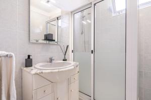 a white bathroom with a sink and a shower at Sallys in Ponta do Sol +27 photos