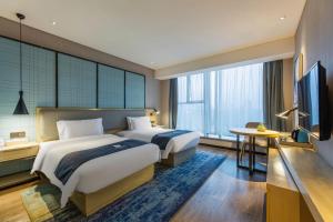 Łóżko lub łóżka w pokoju w obiekcie Echarm Hotel Wuhan Hanyang Wangjiawan Sixin Avenue Metro Station