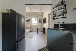 a kitchen with a stainless steel refrigerator and a living room at Luca's home over the Rose Garden in Florence