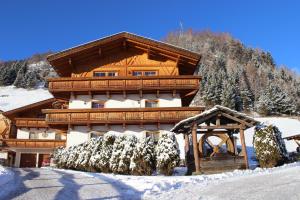 ein großes Holzhaus mit Schnee darauf in der Unterkunft Residence Landhaus Rainer in Ridnaun