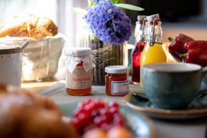 a table with a plate of fruit and a cup of honey at Antares Spiekerooger Gästehaus-Sonnengartenterrasse West - Wohnung 8 in Spiekeroog