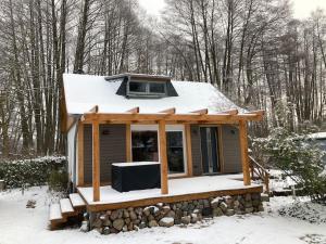 una piccola casa con la neve sopra di Behagliches Cottage am See a Fürstenberg/Havel