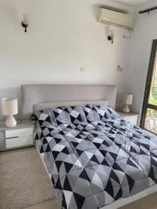 a bedroom with a black and white comforter on a bed at Residence La Marina in Yaoundé