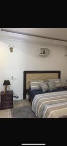 a bedroom with a large bed and a night stand at Residence La Marina in Yaoundé +30 photos