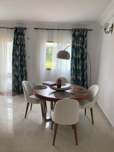 a dining room with a wooden table and chairs at Residence La Marina in Yaoundé