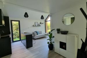 WohlenにあるKleinhauszeit Tiny Houseのソファとテーブルのある白いリビングルーム