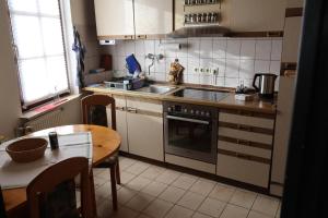 a kitchen with a stove and a sink and a table at Südpfalz in Barbelroth