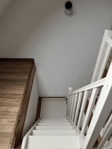 a staircase in a house with white stairs and a light at Duplex Caramel Moderne in Aulnoy