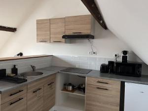 a kitchen with wooden cabinets and a sink at Duplex Caramel Moderne in Aulnoy +11 photos