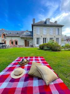 una coperta da picnic sull'erba di fronte a una casa di La Maison Gavraise a Gavray