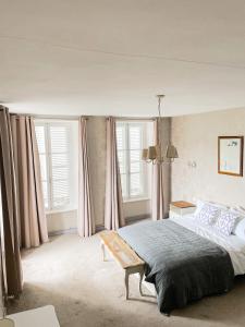 una camera da letto con un grande letto con tende rosa di La Maison Gavraise a Gavray