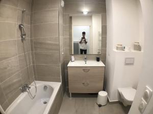 a man taking a picture of a bathroom at Auron- Magnifique 3p neuf in Saint-Étienne-de-Tinée