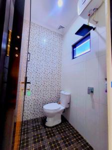 a bathroom with a toilet and a window in it at Adyvan Villa in Malang +11 photos