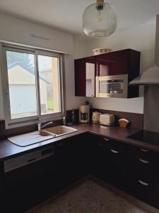 a kitchen with a sink and a microwave at Ty Gwenn in La Baule