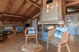 Una sala de estar con chimenea en una cabaña de troncos en La Ferme du Mont, en Servoz