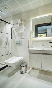 a white bathroom with a toilet and a sink at Modernlux Hotel in Istanbul +26 photos