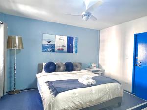 a bedroom with a bed with blue walls and a ceiling at Comfort Home Patong in Patong Beach