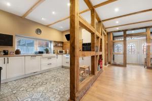 a large kitchen with white cabinets and wooden beams at Nordlichterhof in Neustadt am Rübenberge