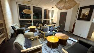 a living room with couches and chairs and tables at Hôtel Club Le 1850 Risoul in Risoul +29 photos