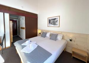 een slaapkamer met een groot bed met handdoeken erop bij Hôtel Club Le 1850 Risoul in Risoul