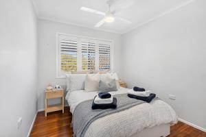 MargateBridgeport pet-friendly Pool Getaway的白色卧室配有一张带吊扇的床 更多11张照片