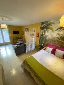 a bedroom with a bed and a living room at Studio paisible in Ruffec