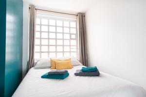 a bed with two pillows on it in front of a window at Le Rayon Vert - Vue sur l'aiguille et garage priv in Étretat