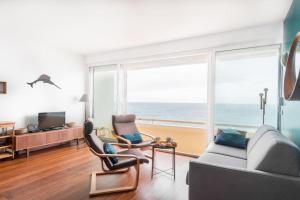a living room with a view of the ocean at Le Rayon Vert - Vue sur l'aiguille et garage priv in Étretat