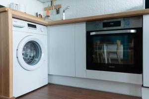 a kitchen with a washing machine and a sink at Le Rayon Vert - Vue sur l'aiguille et garage priv in Étretat