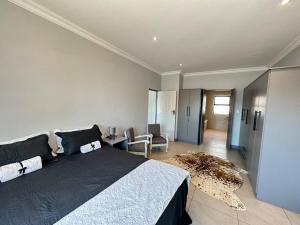 a bedroom with a large bed and a living room at DIE Huis House in Wilderness