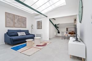 シャルボニエール・レ・バンにあるLoft MEHARI - Le Méridien #Parking #Lave-linge #Clim #Netflixの青いソファとテーブルのあるリビングルーム