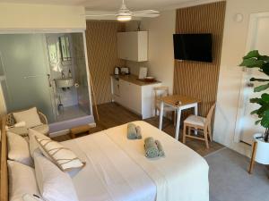 una camera con un grande letto bianco e una cucina di Studio 327 a Woolgoolga