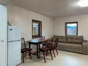 a kitchen with a table and a refrigerator and a couch at Vipche house in Verkhovyna