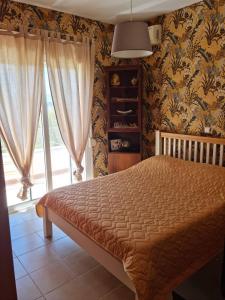 a bedroom with a bed and a large window at Villa athena Crète in Gavalochori