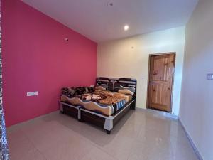 a bedroom with two beds and a red wall at Highland Retreat Kalga in Kalgha