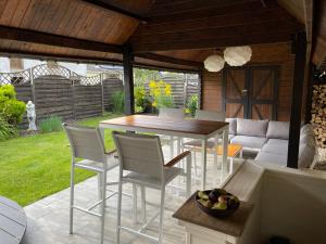 a patio with a table and chairs and a couch at Grange de la Rochette - 1 à 6p in Jamoigne