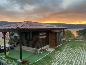 多斯帕特Вила Сънсет 1的一个小木屋，上面挂着一块牌子，写着“日落别墅”。