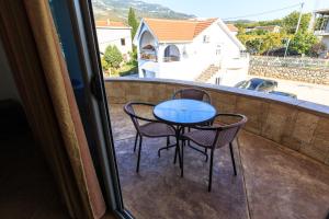 a table and two chairs on a balcony at Apartmani Sejla in Dobra Voda