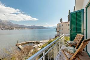 un balcon avec deux chaises et une vue sur l'eau dans l'établissement Detached Villa Njivice Sleeps6 Stunning Views Wifi, à Igalo