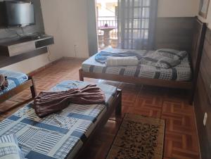Postel nebo postele na pokoji v ubytování QUARTO COM COZINHA E CHURRASQUEIRA PARa ATÉ 7 PESSOAS A SÓ 600 METROS DA BASÍLICA