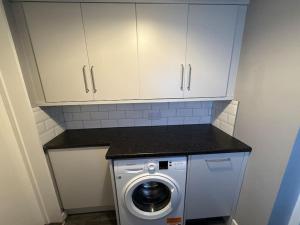 a kitchen with a washing machine and cabinets at Beach house in Newcastle upon Tyne