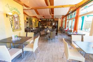a dining room with tables and chairs and windows at Gästehaus Leypold in Murau