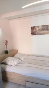 a bed in a bedroom with a painting on the wall at Magnifique Studio au cœur historique de Fréjus in Fréjus